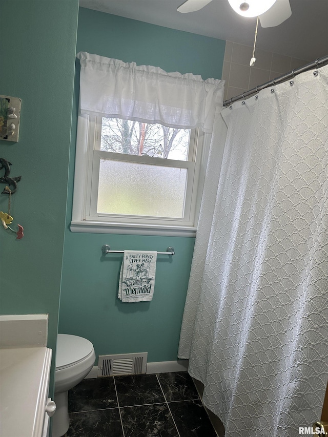 bathroom with tile patterned flooring, vanity, toilet, and ceiling fan