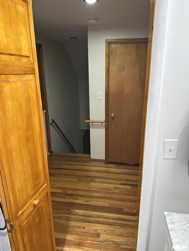 stairs featuring hardwood / wood-style flooring and lofted ceiling