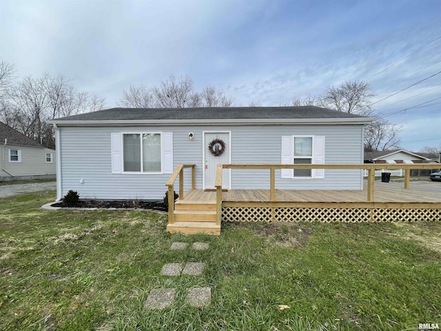 view of front of property with a deck and a front lawn