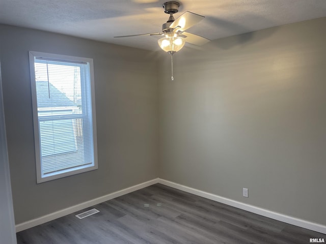 spare room with dark hardwood / wood-style floors, ceiling fan, and a textured ceiling