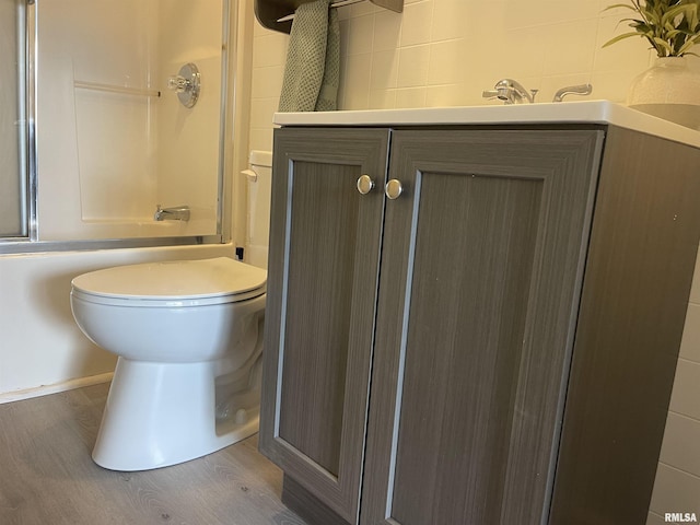 bathroom with vanity, combined bath / shower with glass door, and wood-type flooring