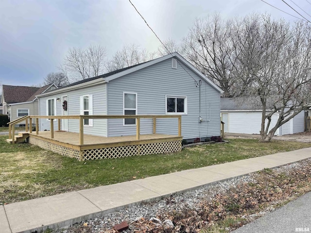 view of home's exterior with a wooden deck and a yard