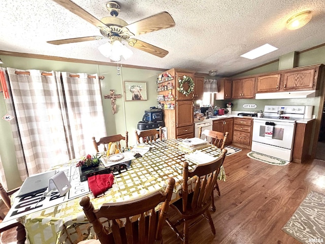 dining area with ceiling fan, lofted ceiling, ornamental molding, wood finished floors, and a textured ceiling