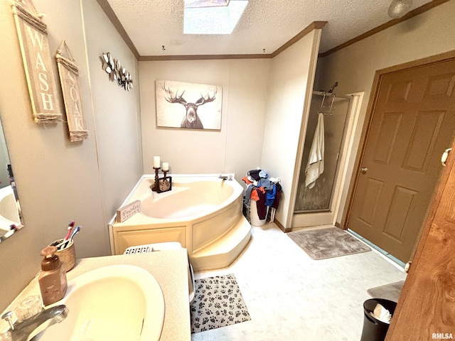 bathroom with a stall shower, a sink, a textured ceiling, a skylight, and crown molding