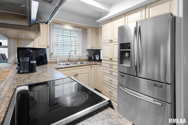 kitchen featuring sink, ornamental molding, stainless steel fridge, cream cabinets, and range