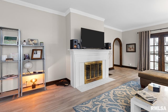 living room with ornamental molding, light hardwood / wood-style flooring, and a brick fireplace