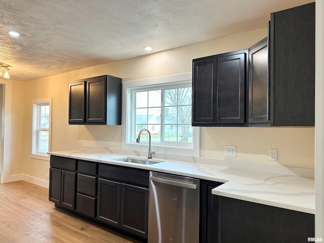 kitchen with dishwasher, a textured ceiling, light wood-type flooring, and sink