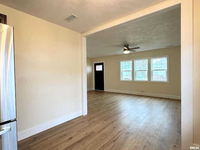 unfurnished room with ceiling fan, hardwood / wood-style floors, and a textured ceiling