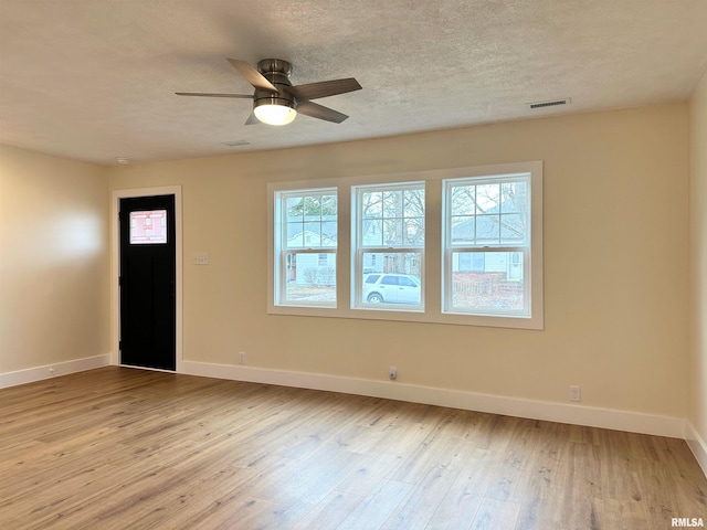 interior space with ceiling fan, plenty of natural light, a textured ceiling, and light wood-type flooring