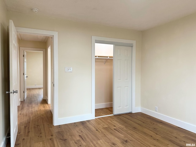 unfurnished bedroom with hardwood / wood-style floors and a closet