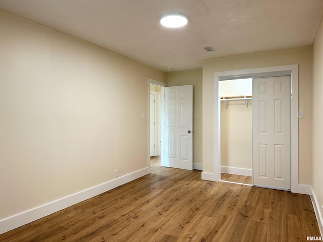 unfurnished bedroom with light hardwood / wood-style flooring and a closet