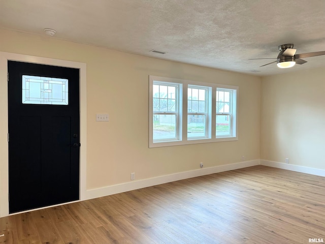 entrance foyer featuring ceiling fan, light hardwood / wood-style floors, and a textured ceiling