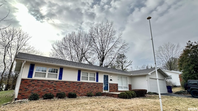 ranch-style home featuring a garage, aphalt driveway, and brick siding