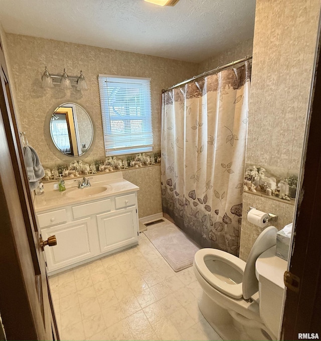 bathroom with vanity, a textured ceiling, and toilet