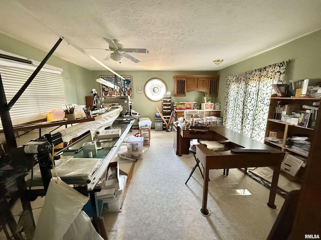 miscellaneous room with ceiling fan, light colored carpet, and a textured ceiling