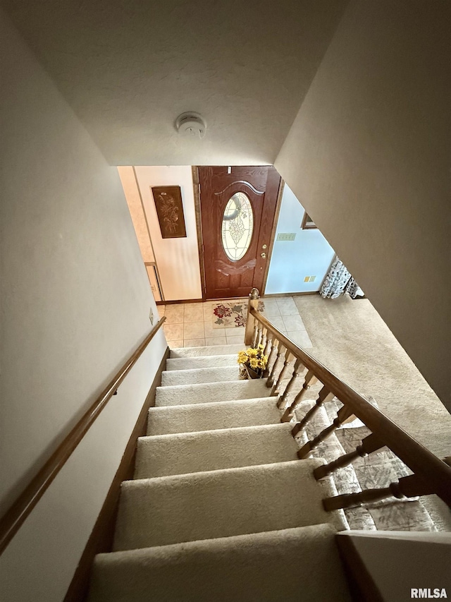 staircase featuring tile patterned floors