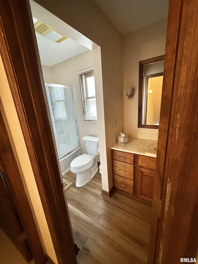 full bathroom with hardwood / wood-style floors, vanity, toilet, and shower / bath combination with glass door