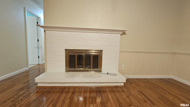 room details featuring wood-type flooring and a brick fireplace