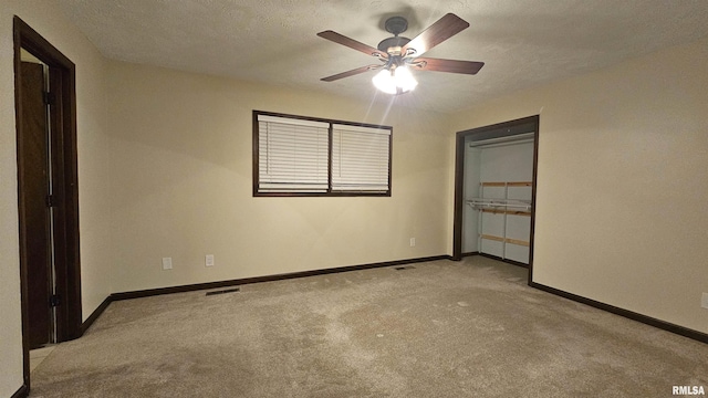 unfurnished bedroom featuring light carpet, a textured ceiling, a closet, and ceiling fan