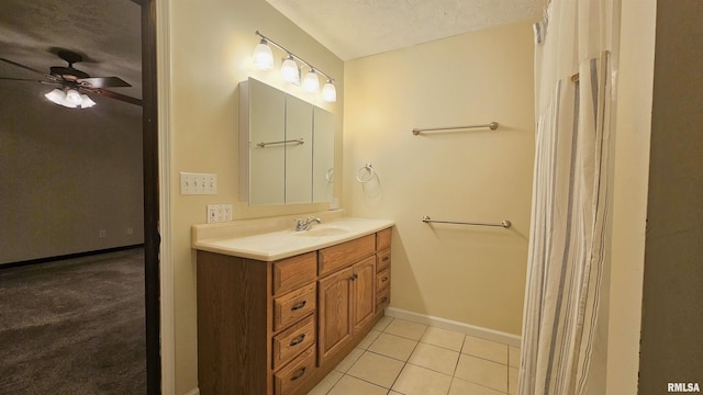 bathroom with tile patterned floors, vanity, ceiling fan, and a textured ceiling