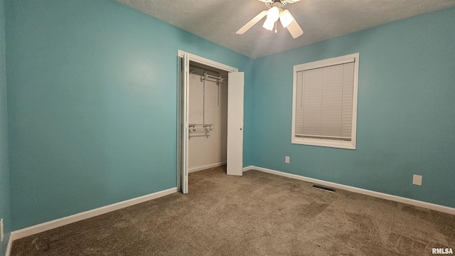 unfurnished bedroom featuring ceiling fan, a closet, carpet, and a textured ceiling