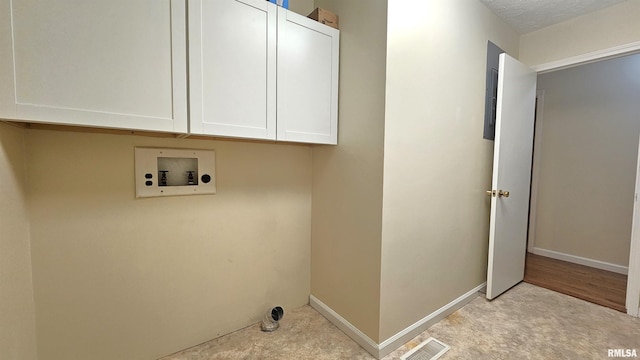 washroom featuring cabinets, hookup for a washing machine, and a textured ceiling