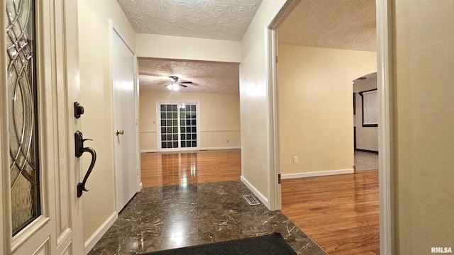 corridor featuring a textured ceiling and hardwood / wood-style flooring