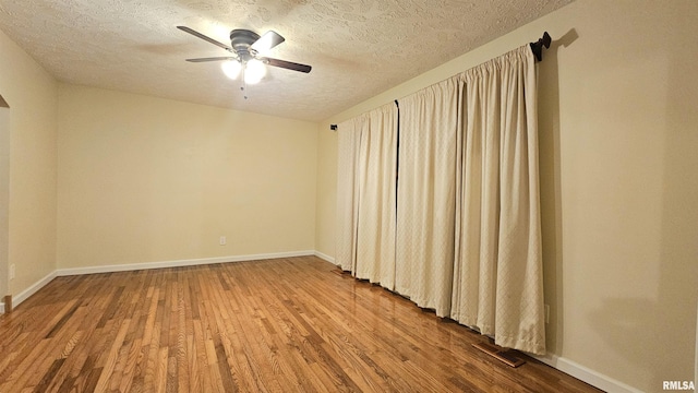 empty room with wood-type flooring, a textured ceiling, and ceiling fan