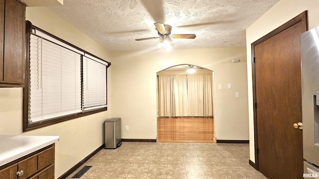 interior space featuring vanity, a textured ceiling, and ceiling fan