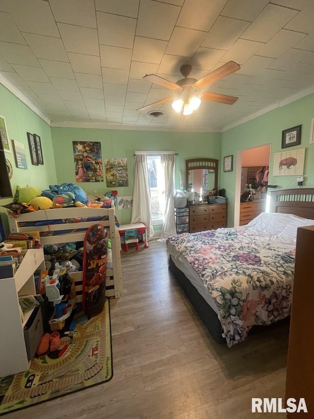 bedroom with hardwood / wood-style flooring, ceiling fan, and crown molding