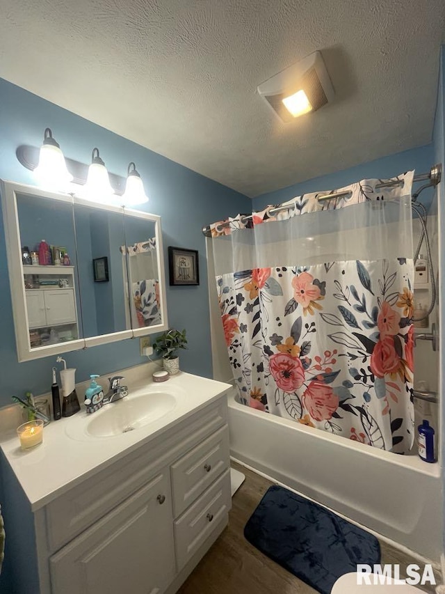 bathroom with vanity, shower / bath combo, a textured ceiling, and hardwood / wood-style flooring