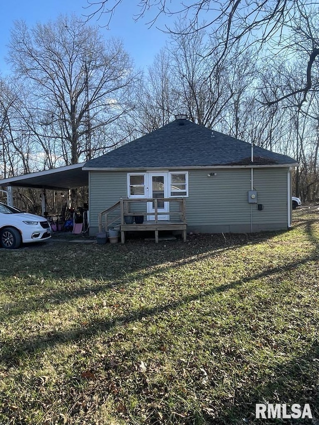 rear view of property featuring a deck, a carport, and a lawn