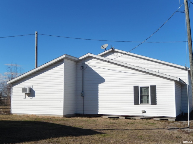 view of home's exterior featuring a wall unit AC and a lawn