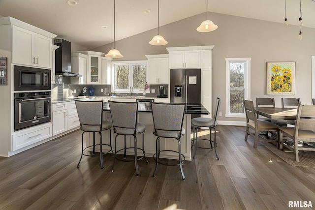 kitchen with white cabinetry, wall chimney range hood, backsplash, pendant lighting, and black appliances