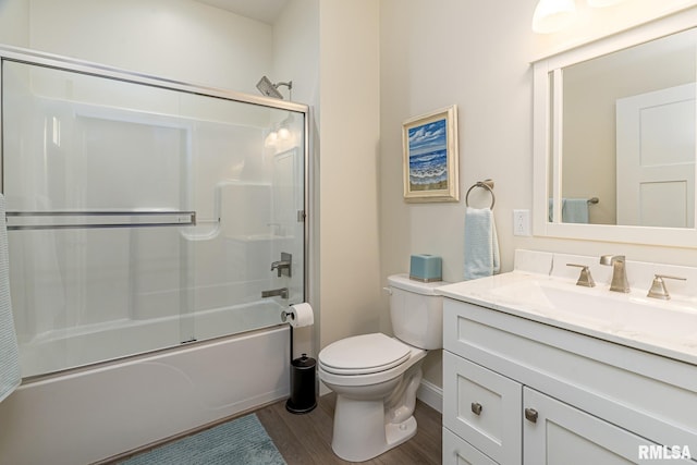 full bathroom featuring combined bath / shower with glass door, wood-type flooring, vanity, and toilet