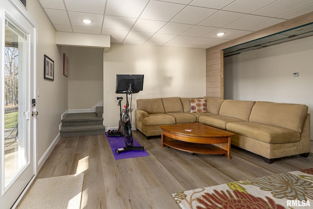 living room featuring light wood-type flooring and a paneled ceiling