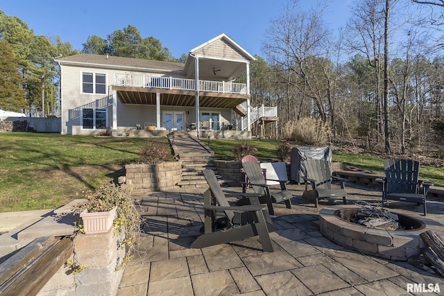 rear view of house featuring a lawn, ceiling fan, french doors, a fire pit, and a patio area