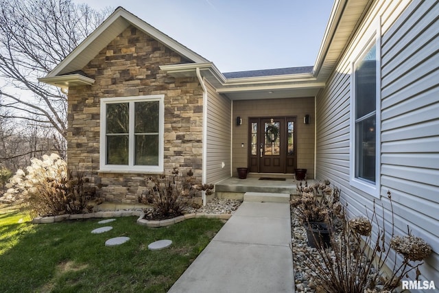 view of exterior entry with a lawn