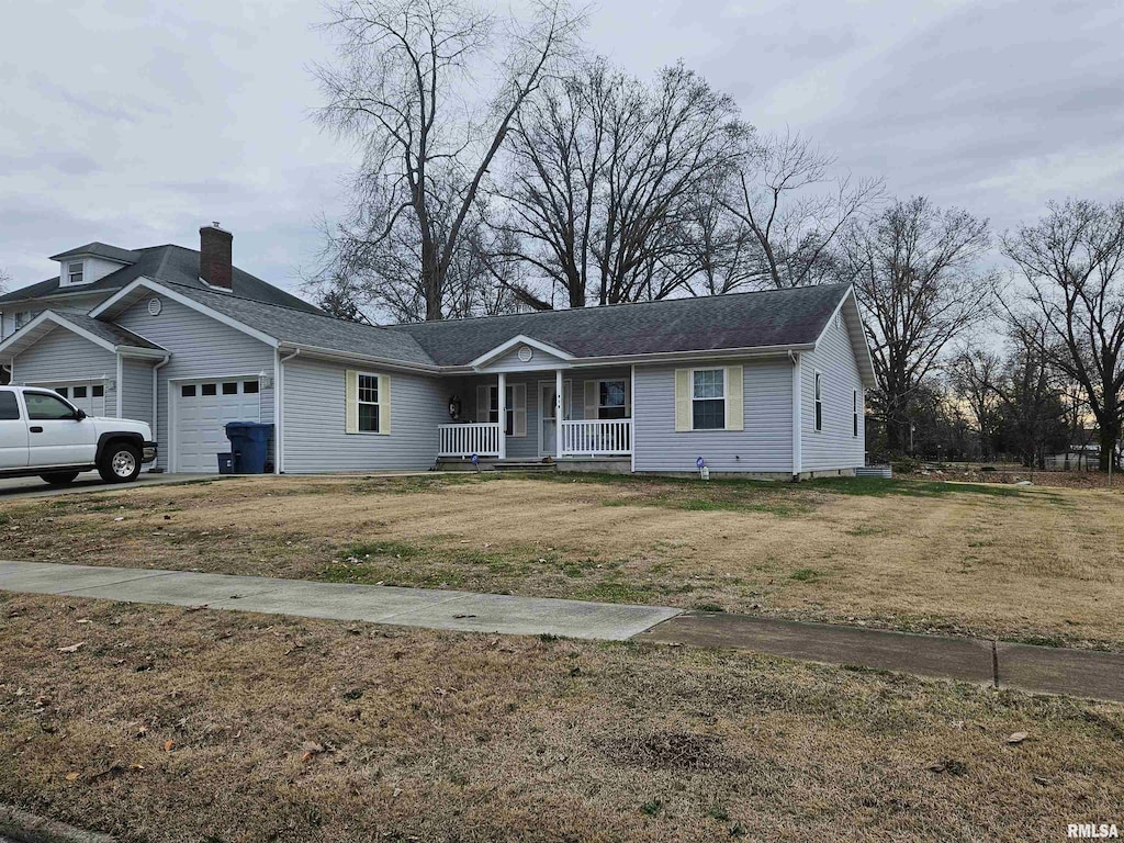 view of front facade with covered porch, a garage, and a front lawn