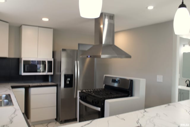 kitchen with exhaust hood, white cabinets, hanging light fixtures, appliances with stainless steel finishes, and tasteful backsplash