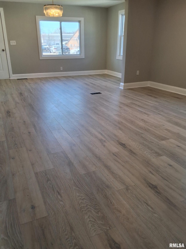 309 W 11th St, Metropolis, IL 62960 - unfurnished room with visible vents, baseboards, a chandelier, and wood finished floors