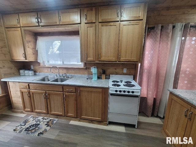 kitchen featuring white electric range, hardwood / wood-style flooring, and sink