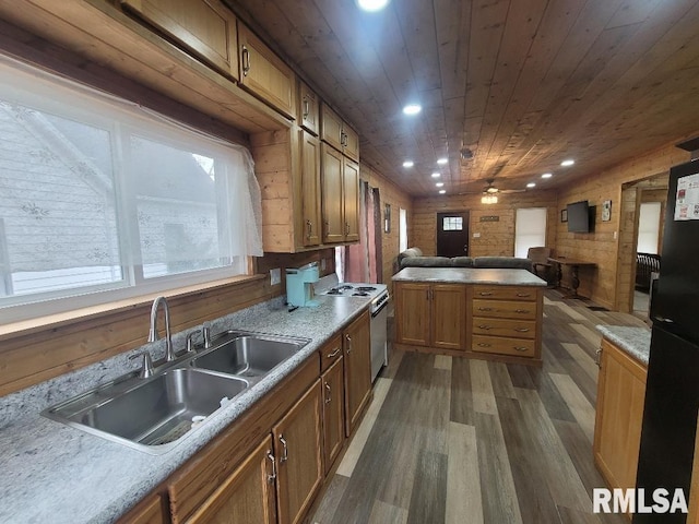 kitchen with wood ceiling, wooden walls, dark wood-type flooring, sink, and stainless steel stove