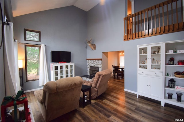 living room featuring a stone fireplace, dark wood-type flooring, and high vaulted ceiling