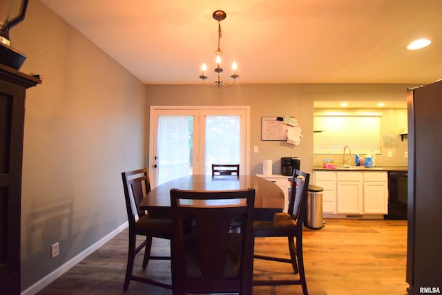 dining area with a chandelier, light hardwood / wood-style floors, and sink