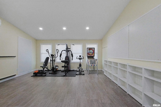 exercise room featuring hardwood / wood-style floors and vaulted ceiling