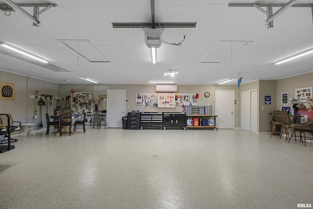 garage featuring a garage door opener and a wall mounted AC