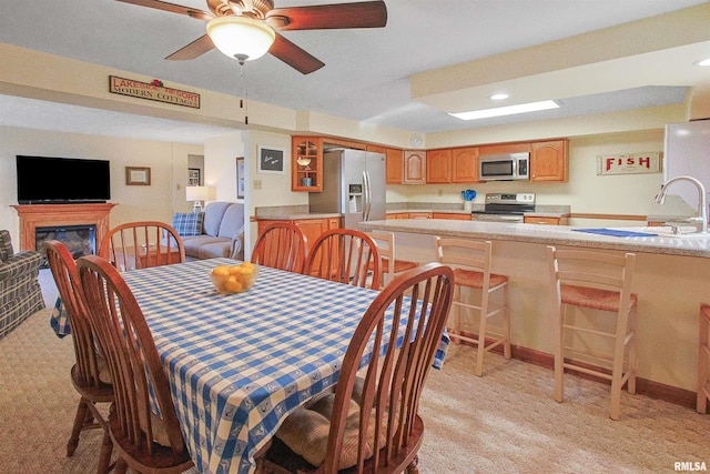 carpeted dining area with ceiling fan and sink