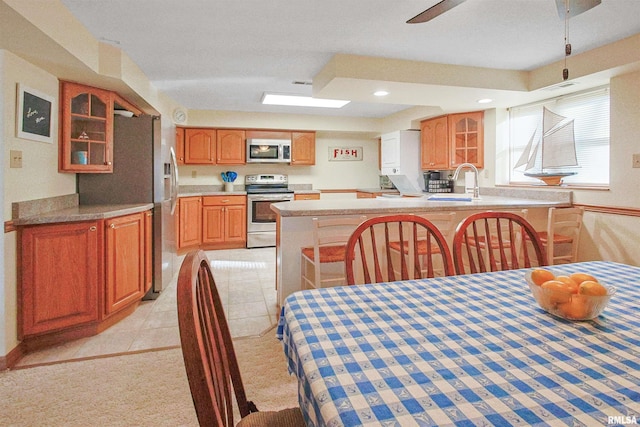 dining room with ceiling fan, light tile patterned floors, and sink