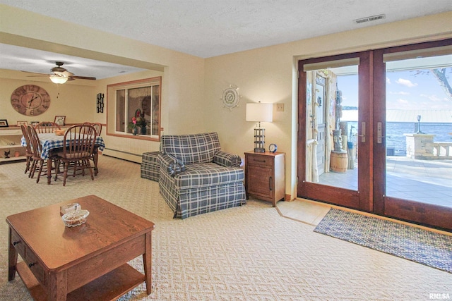 carpeted living room with ceiling fan, french doors, baseboard heating, a textured ceiling, and a water view